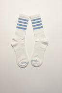 Sucka Proof white crew socks with sky blue athletic stripes and signature branding.